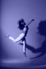 Fitness girl dancing in the studio in lilac color.