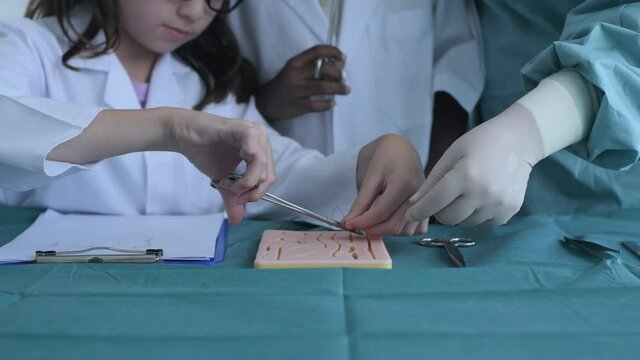 Education concept of 4k Resolution. Medical school students practicing suturing wounds in classroom. internship doctor. training simulation.
