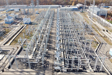 Aerial view of industrial high-voltage power lines, pylons and transformers. Electric transformation station. High angle view of transformer power plant