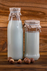 Lactose-free free-dairy macadamia products, mock-up. Bottles with milk, cheese, sour cream, butter on a wooden background. Fresh food