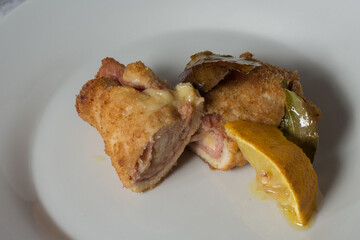 chicken rolls with smoked scamorza cheese and cooked ham and passed in breadcrumbs. Baked with bay leaf and lemon slices
