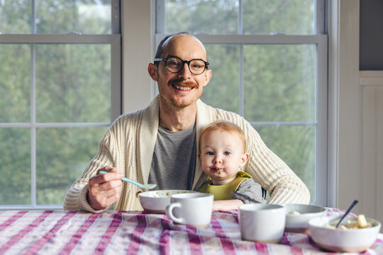 A father enjoys breakfast with his daughter at home