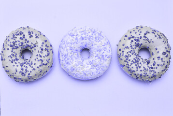 Delicious donuts in trendy violet color. Lilac color donuts dessert with copy space.