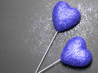Two violet hears on festive background with a glitters. Trendy color very peri, Color of the year 2022.