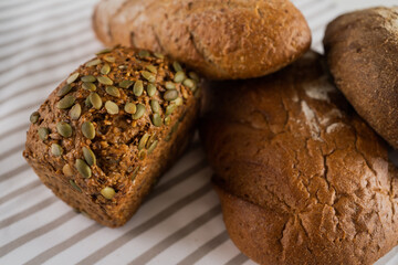 Fresh pastries for breakfast. Homemade bread with seeds on the table.