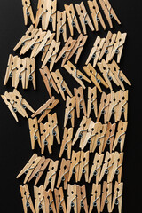 wood clothespins in roe on black background