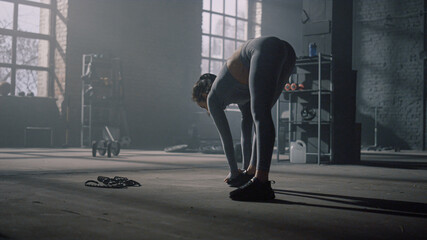 Fototapeta na wymiar Girl doing stretching exercises before training. Woman warming body in gym