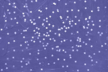 Color of the year 2022 Very Peri. Shiny stars on dark blue background. Winter abstract background in trendy color. New Year party, Christmas celebration, holidays, dreams concept. Selective focus