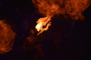 Someone doing a fire show at night in an open field