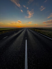 Obraz na płótnie Canvas Beautiful look of an infinite road, highway going to a sunset in the Iceland highlands