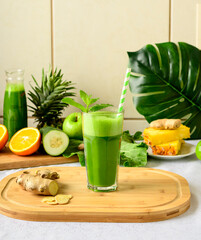 detox green juice, glass with green juice on a wooden board, small fruit ingredient for the juice...