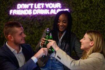 Colleagues working on a laptop and having a meeting in a cafe while toasting