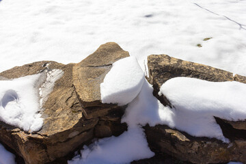 Winter, a mountain chalet, the ground covered with snow, the stones thawed from the snow in the...