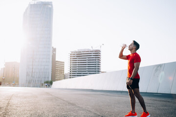 Fototapeta na wymiar Young athletic man drinking water from bottle