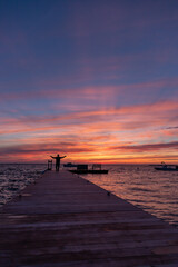 Fototapeta na wymiar Silhouette of man raising his arms beneath incredible sunset sky.