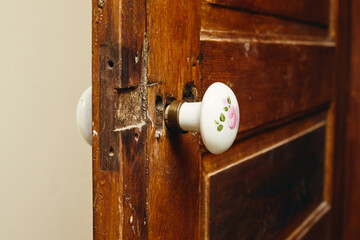 poignée de porte ancienne sur porte en bois en céramique avec motif floral 