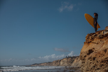 Black Woman carrying a surfboard
