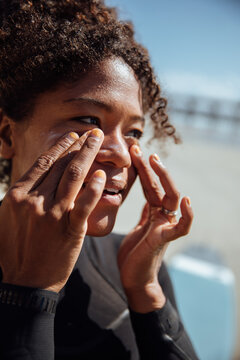 Woman applying sunscreen on the beach