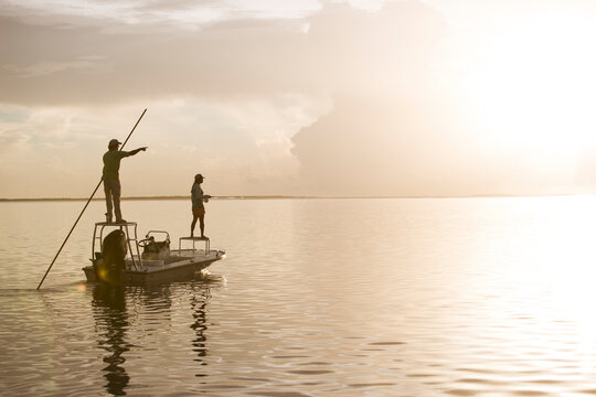 A man and woman fly fishing on a flats boat in the Florida Keys