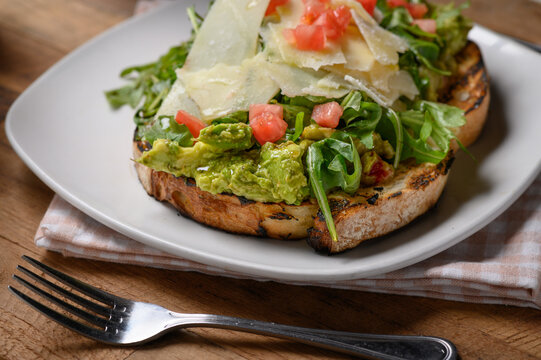 Crostini with avocado, parmesan cheese and tomato