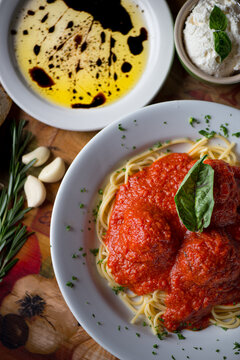 Spaghetti meatball with a basil leave, ricotta cheese, garlic, and oil