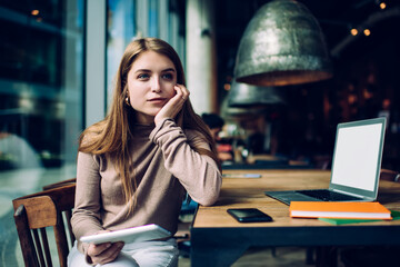 Young woman looking away while doing job in coworker space