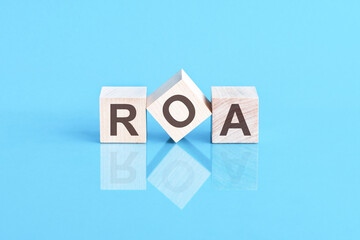 ROA - acronym from wooden blocks with letters, front view on blue background