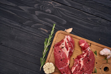 meat steak wooden board and spices ingredients top view