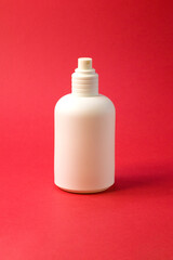 Womens perfume in white beautiful bottle on bright red textured fabric background