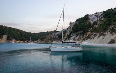Yachts on anchor in turquoise sea water between rocky seashore islands
