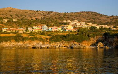 Panoram of the small town with multicolored houses on the hill with mountains on the background