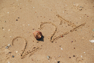 Fototapeta na wymiar Word 2021 Written on the Sand of a Beach. New Year 2021 text on the sea beach