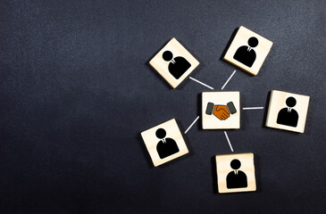 Agreement, partnership or deal concept. People and handshake Icons on wooden blocks.