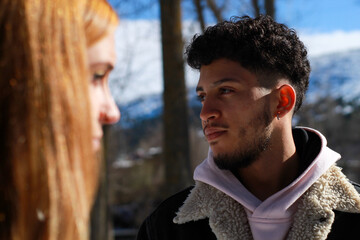 portrait of latin man looking to the side with unfocused foreground of his partner's face