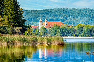 Fototapeta premium Klosterkirche Schlehdorf spiegelt sich im Kochelsee im Blauen Land