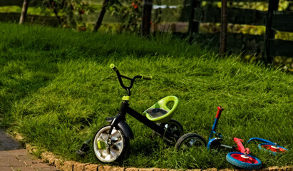 Dziecięce rowerki  porzucone  na trawniku . Children's bikes abandoned on the lawn.