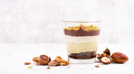 Dessert with chocolate cream, cake and nuts in a glass, sweet food, christmas season