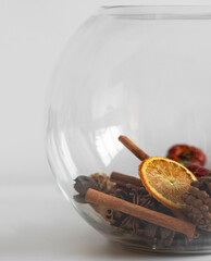 orange and cinnamon potpourri in fish bowl vase