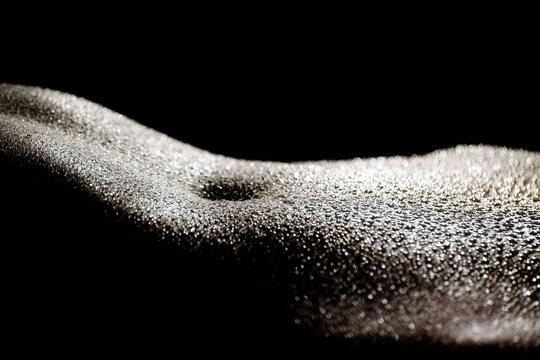 Female naked sexy flat belly in water drops on black background