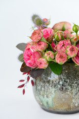 Flowers bouquet in glazed vase on white background