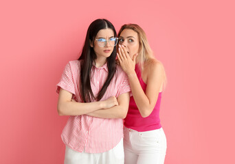 Young gossiping women on color background - obrazy, fototapety, plakaty