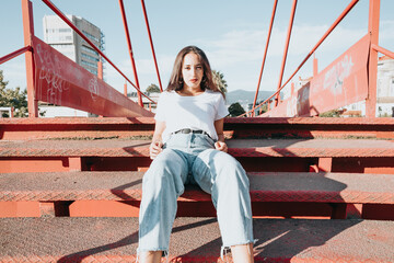 Cool hipster african young girl with curly hair, street hip hop style, looking serious defiant to...