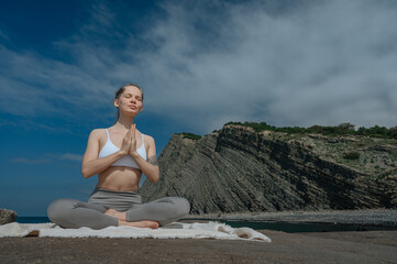 Fototapeta na wymiar Yoga practice and meditation in nature. Woman practicing near Black sea.