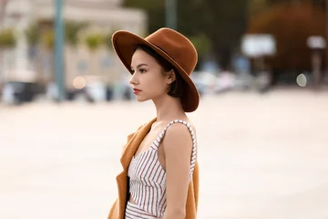 Foto op Canvas Young fashionable woman in felt hat on city street © Pixel-Shot