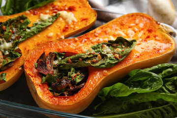Baking dish with tasty stuffed pumpkins on table, closeup