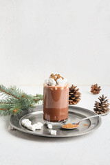 Glass of tasty coffee with cinnamon and marshmallows on white background