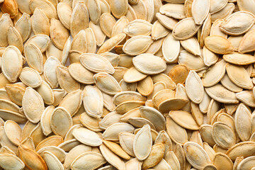 Natural pumpkin seeds as background, closeup