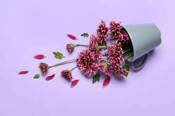Composition with cup and chrysanthemum flowers on lilac background