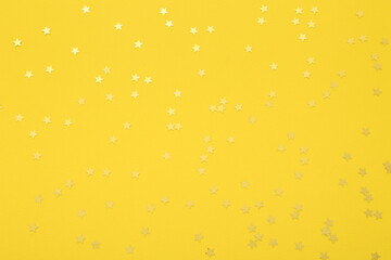 Beautiful golden confetti on yellow background