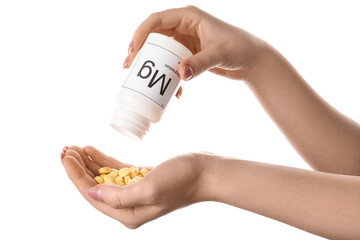 Female hands with bottle of magnesium pills on white background, closeup - obrazy, fototapety, plakaty